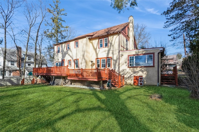 back of property with a lawn and a deck