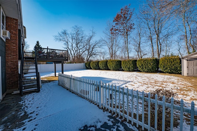 snowy yard with cooling unit and a shed