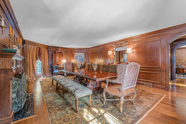 183 Mill Spring Rd, Manhasset, NY 11030 - dining room with arched walkways, ornamental molding, wooden walls, and wood finished floors