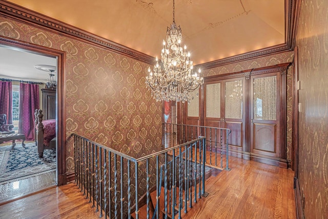 183 Mill Spring Rd, Manhasset, NY 11030 - hallway featuring wallpapered walls, wood finished floors, an upstairs landing, and an inviting chandelier