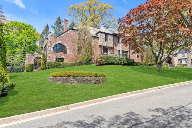 183 Mill Spring Rd, Manhasset, NY 11030 - tudor home featuring a front yard, brick siding, and stone siding