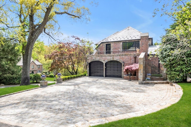 183 Mill Spring Rd, Manhasset, NY 11030 - view of front facade featuring a high end roof, brick siding, decorative driveway, a garage, and a balcony