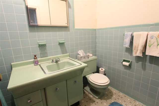 bathroom with vanity, tile walls, tile patterned floors, and toilet