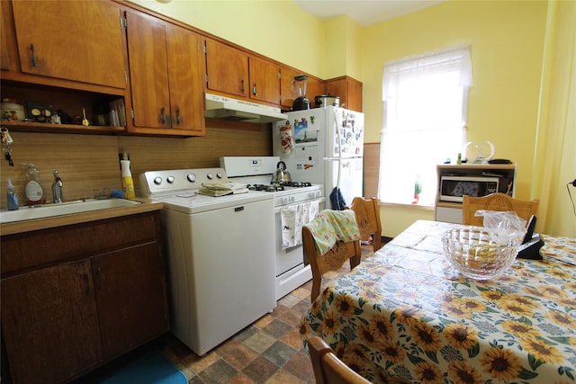 kitchen with washer / clothes dryer, white appliances, and sink