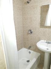 bathroom featuring tiled shower / bath