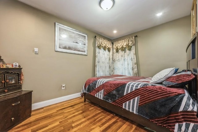 bedroom featuring a wood stove and light wood-type flooring