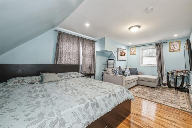 bedroom featuring lofted ceiling and hardwood / wood-style floors