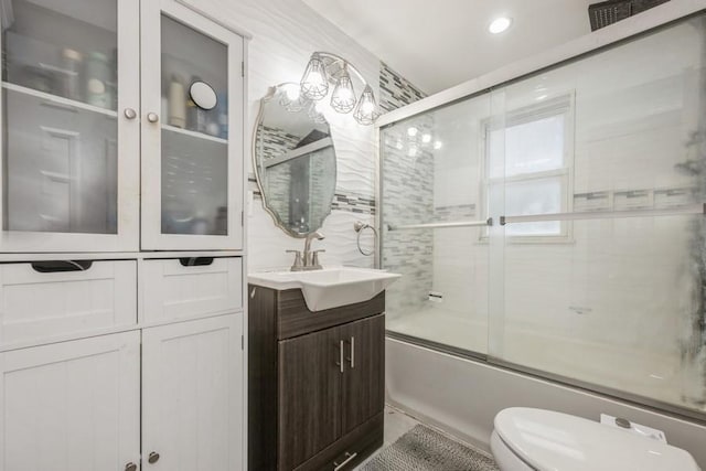 full bathroom with vanity, enclosed tub / shower combo, and toilet