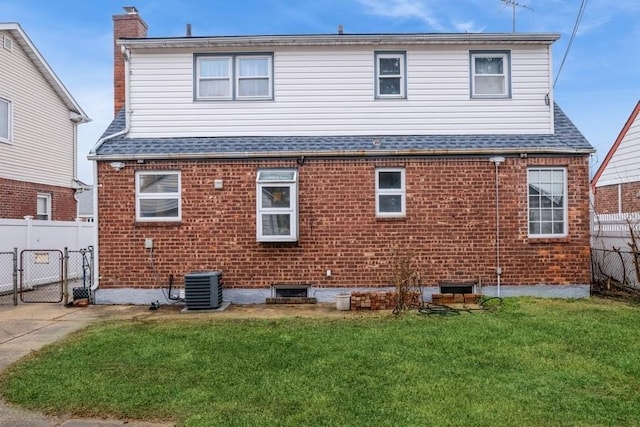 back of house with a yard and central air condition unit