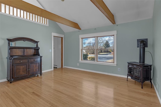 living room with lofted ceiling with beams, light hardwood / wood-style flooring, and a wood stove