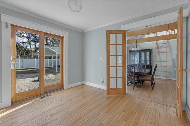 interior space with crown molding, french doors, and light wood-type flooring