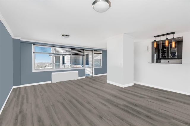 unfurnished living room featuring ornamental molding, dark wood-type flooring, and a wealth of natural light