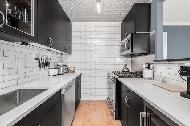 kitchen with wine cooler, sink, decorative backsplash, and appliances with stainless steel finishes