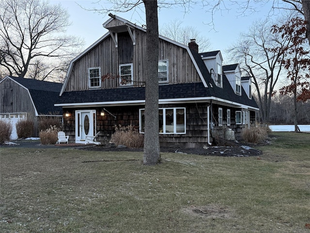 view of front of home with an outdoor structure and a front lawn