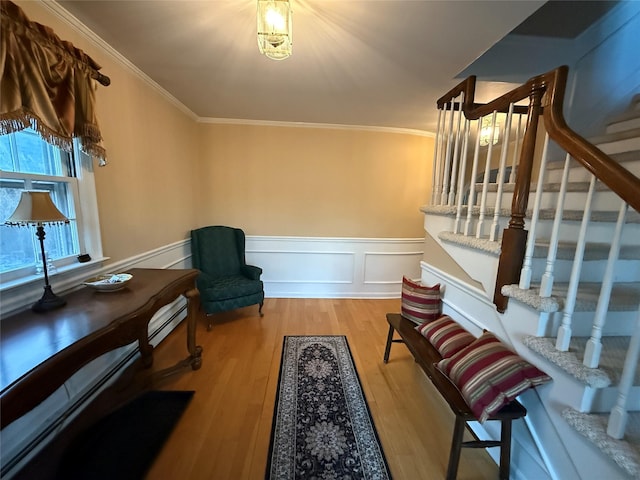 living area with crown molding and hardwood / wood-style flooring