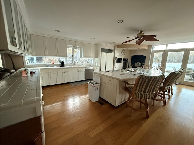 kitchen with stainless steel dishwasher, white cabinets, and a kitchen island