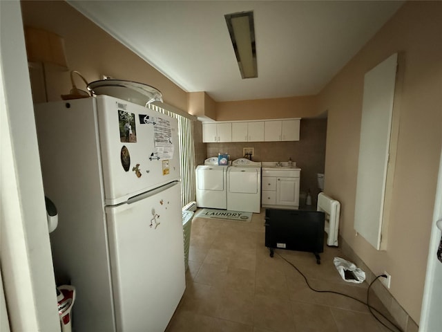 kitchen with white cabinetry, independent washer and dryer, white fridge, and light tile patterned floors