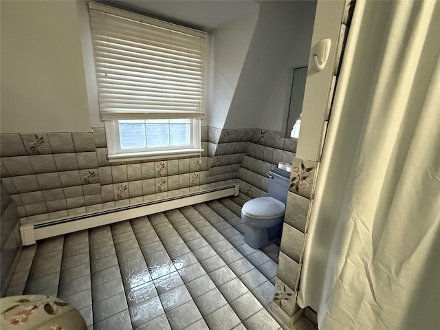 bathroom featuring baseboard heating, toilet, tile patterned flooring, and tile walls