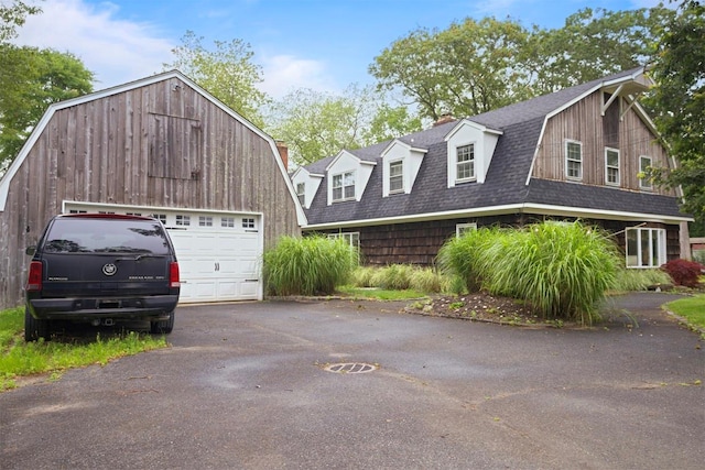1 Lake Dr, Middle Island, NY 11953 - dutch colonial featuring a gambrel roof, roof with shingles, a garage, an outbuilding, and asphalt driveway