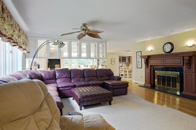1 Lake Dr, Middle Island, NY 11953 - living area featuring healthy amount of natural light, a fireplace, light wood-style floors, and a ceiling fan