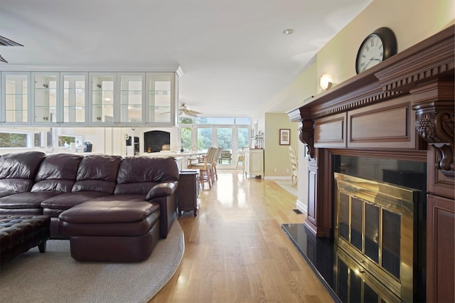 1 Lake Dr, Middle Island, NY 11953 - living room featuring a glass covered fireplace, ceiling fan, and light wood-type flooring