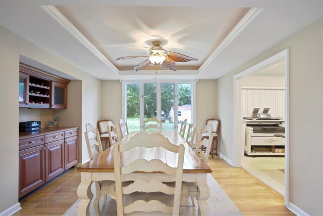 1 Lake Dr, Middle Island, NY 11953 - dining room featuring a tray ceiling, a ceiling fan, light wood-style floors, and ornamental molding