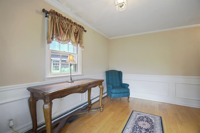 1 Lake Dr, Middle Island, NY 11953 - living area with crown molding, a baseboard heating unit, hardwood / wood-style floors, wainscoting, and a decorative wall