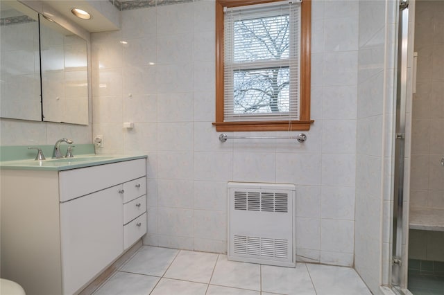 bathroom featuring tile patterned flooring, heating unit, and tile walls