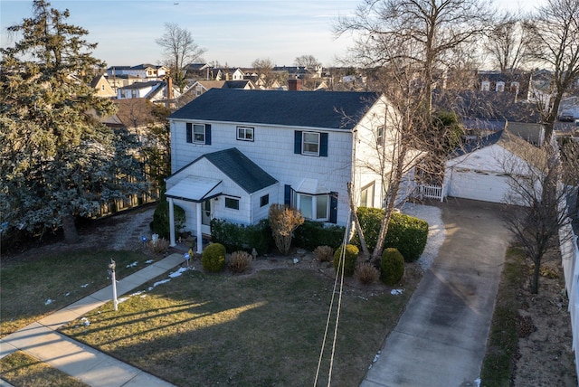 view of front of home featuring an outbuilding, a garage, and a front yard