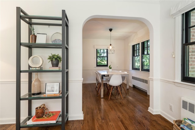 dining area with radiator and dark wood-type flooring