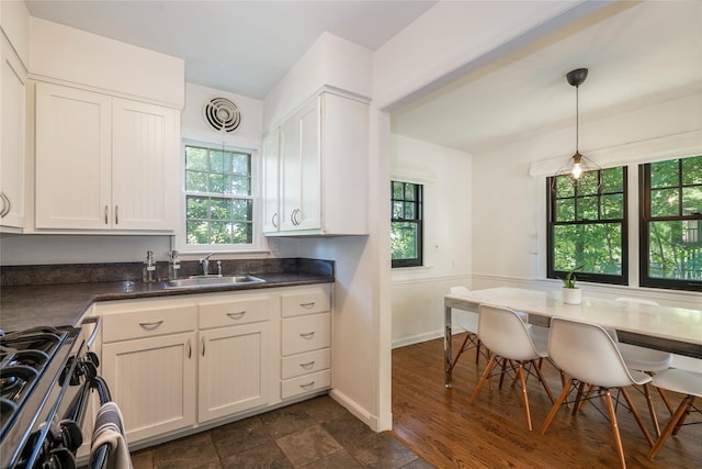 kitchen featuring white cabinetry, sink, pendant lighting, and a healthy amount of sunlight