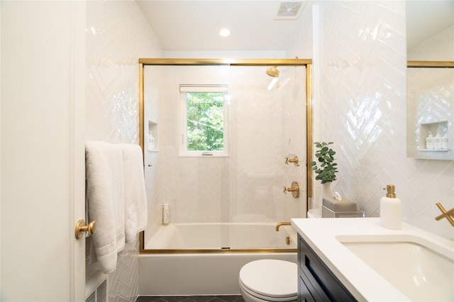 full bathroom with shower / bath combination with glass door, tile walls, vanity, decorative backsplash, and toilet