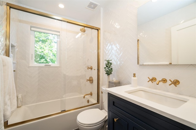 full bathroom featuring enclosed tub / shower combo, tile walls, vanity, decorative backsplash, and toilet