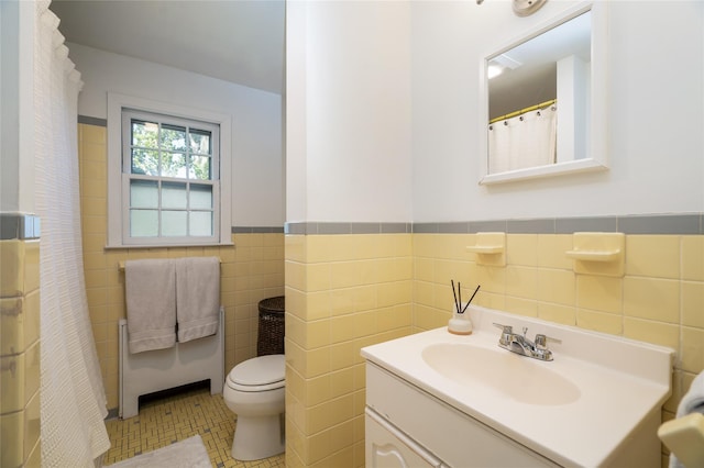 bathroom with vanity, tile walls, tile patterned floors, and toilet