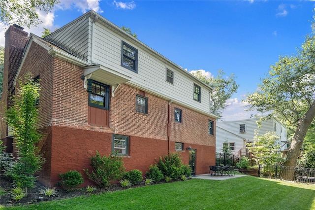 rear view of house featuring a patio and a lawn