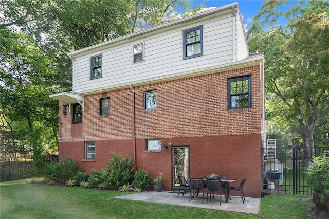 back of house featuring a lawn and a patio