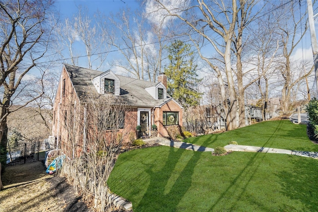 cape cod home featuring a front yard