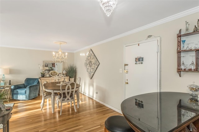 dining room featuring an inviting chandelier, hardwood / wood-style floors, and ornamental molding