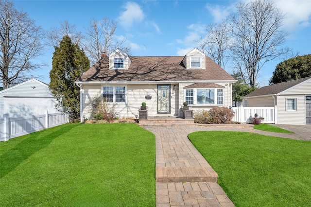 cape cod house featuring a garage, an outdoor structure, and a front lawn