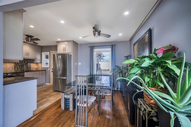 kitchen with wood-type flooring, stainless steel fridge, gray cabinets, ceiling fan, and backsplash