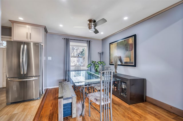 dining space with ornamental molding, ceiling fan, and light wood-type flooring