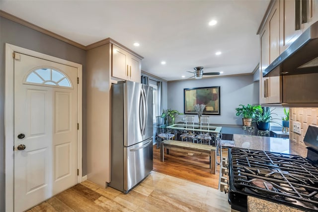 kitchen with stainless steel refrigerator, black range with gas cooktop, light hardwood / wood-style floors, and crown molding