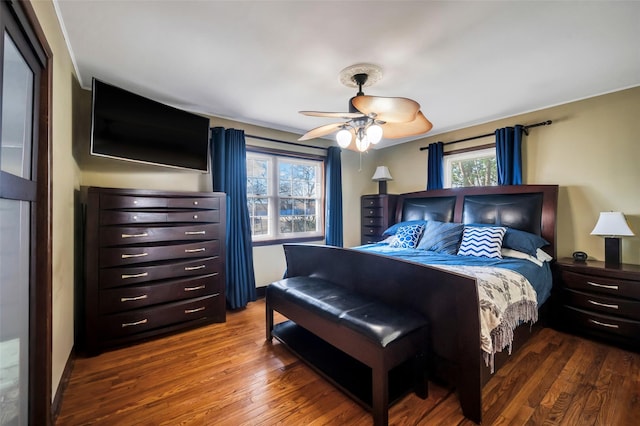 bedroom with dark hardwood / wood-style flooring and ceiling fan