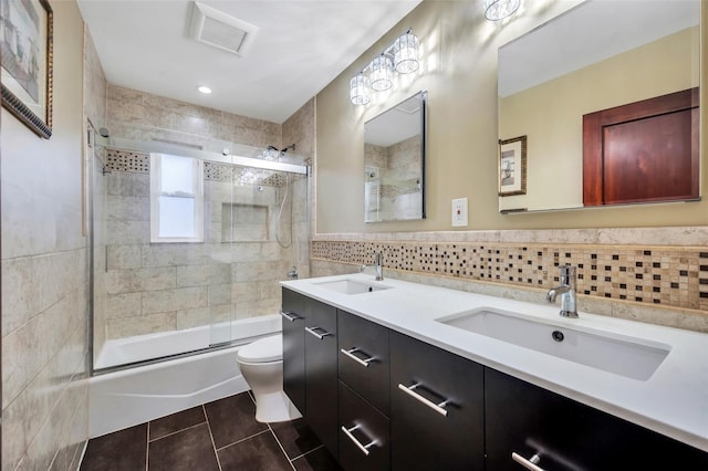 full bathroom with enclosed tub / shower combo, tile walls, vanity, tile patterned floors, and toilet