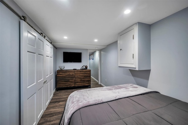 bedroom with dark hardwood / wood-style floors and a barn door