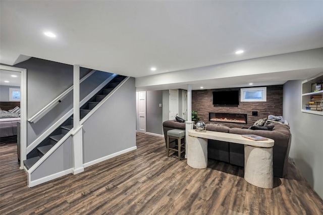 living room featuring dark wood-type flooring and a large fireplace