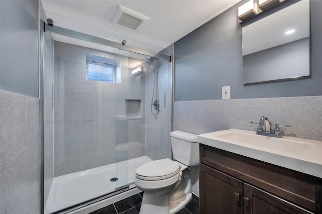 bathroom featuring walk in shower, vanity, toilet, and tile walls