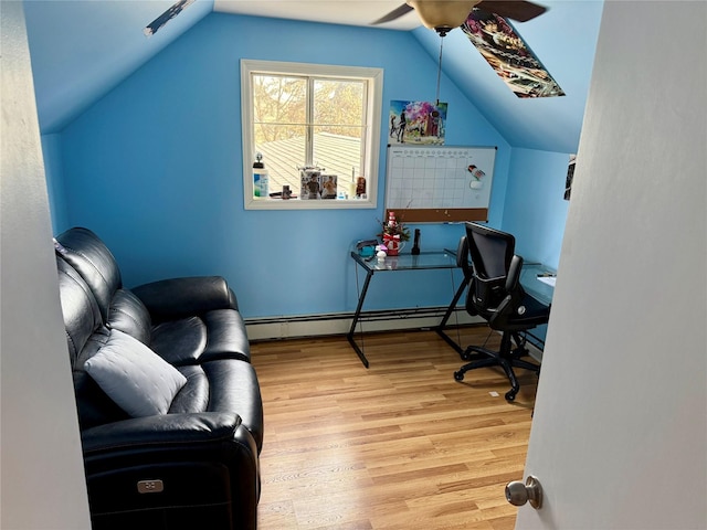 home office featuring ceiling fan, a baseboard radiator, vaulted ceiling, and light hardwood / wood-style flooring