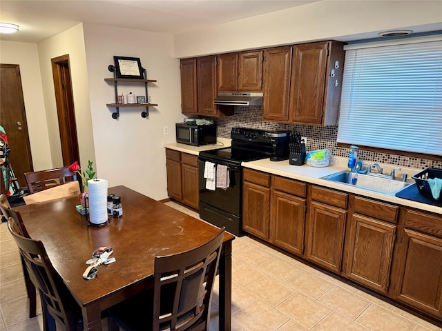 kitchen featuring tasteful backsplash, light tile patterned floors, sink, and black appliances