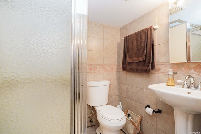 bathroom with sink, tile walls, backsplash, an enclosed shower, and toilet